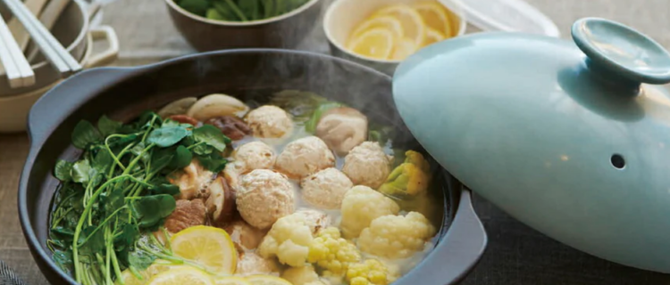 つみれ、三つ葉、カリフラワー、レモンを使用した鍋料理が土鍋で調理されている様子。