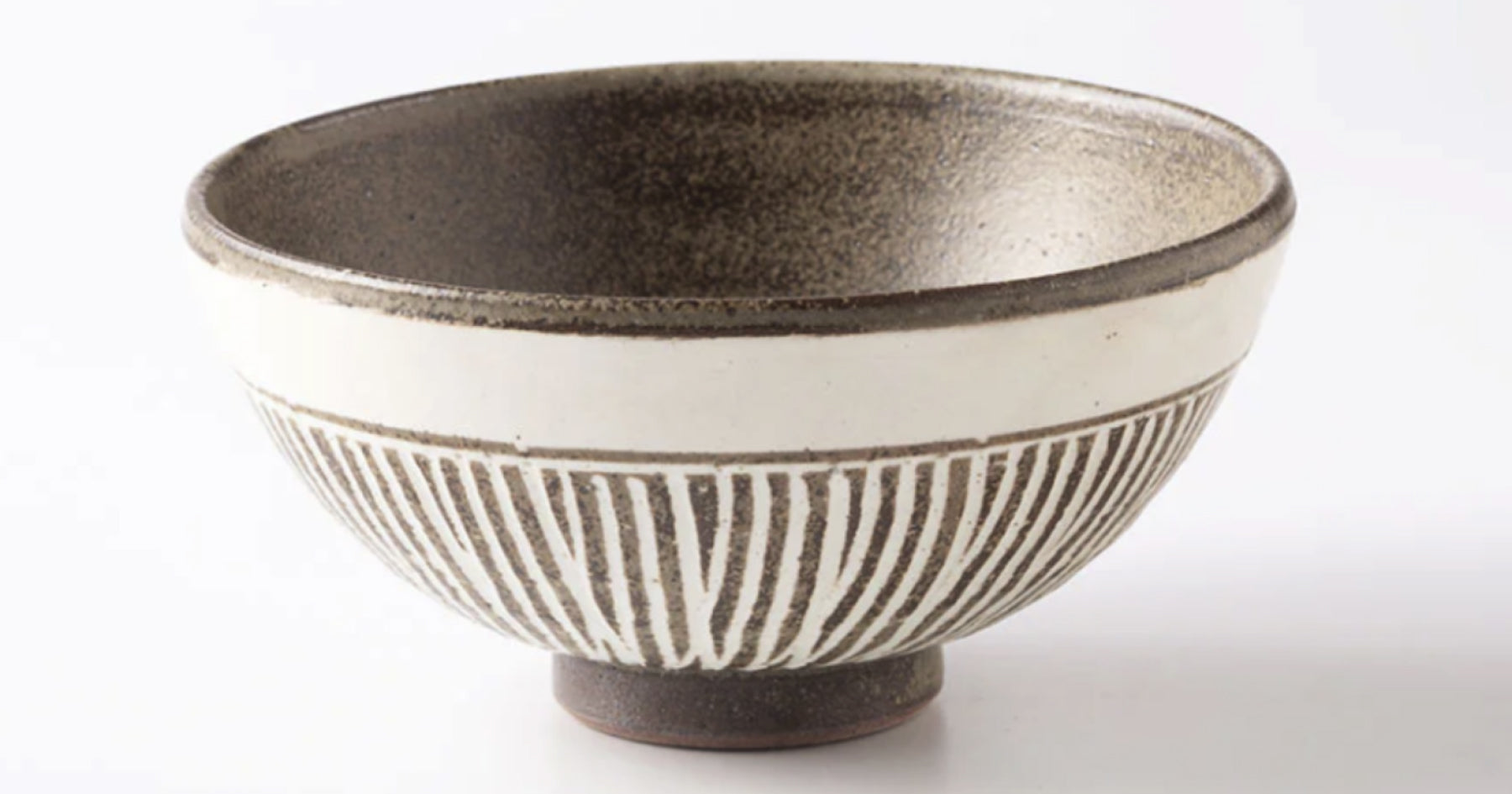 白地に黒い線模様が描かれた陶器のお茶碗。内側は黒く、外側は白い背景に黒の模様が入っている。