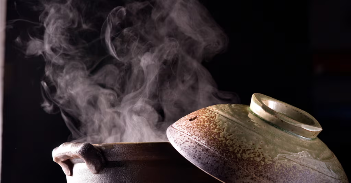 蓋がずらされ、蒸気が立ち上る土鍋